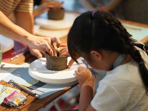 子供のイベントで陶芸教室の手びねり出張体験をする小学生